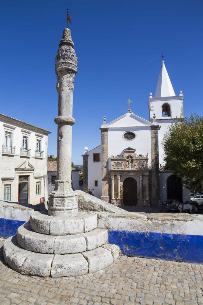 Pelourinho da cidade de Óbidos, em Portugal, com a Igreja de Santa Maria ao fundo