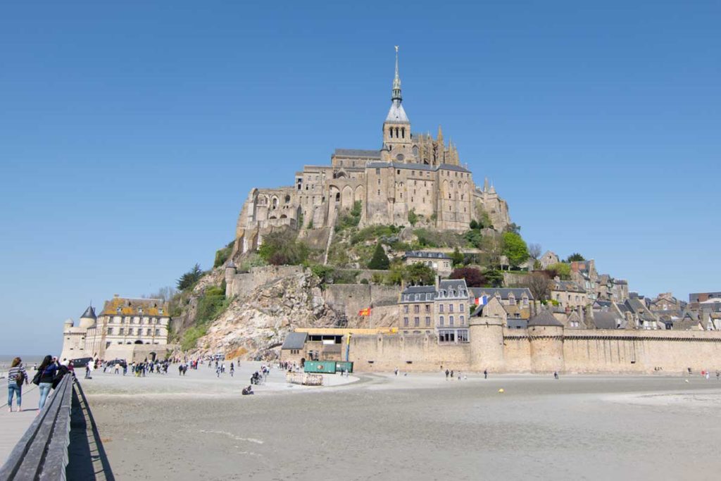 Visitantes caminham ao redor do Mont Saint-Michel, na França, durante a maré baixa