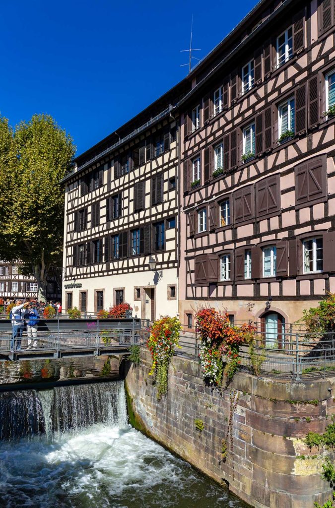 Casal admira casas no estilo enxaimel no bairro de Petite-France, em Estrasburgo