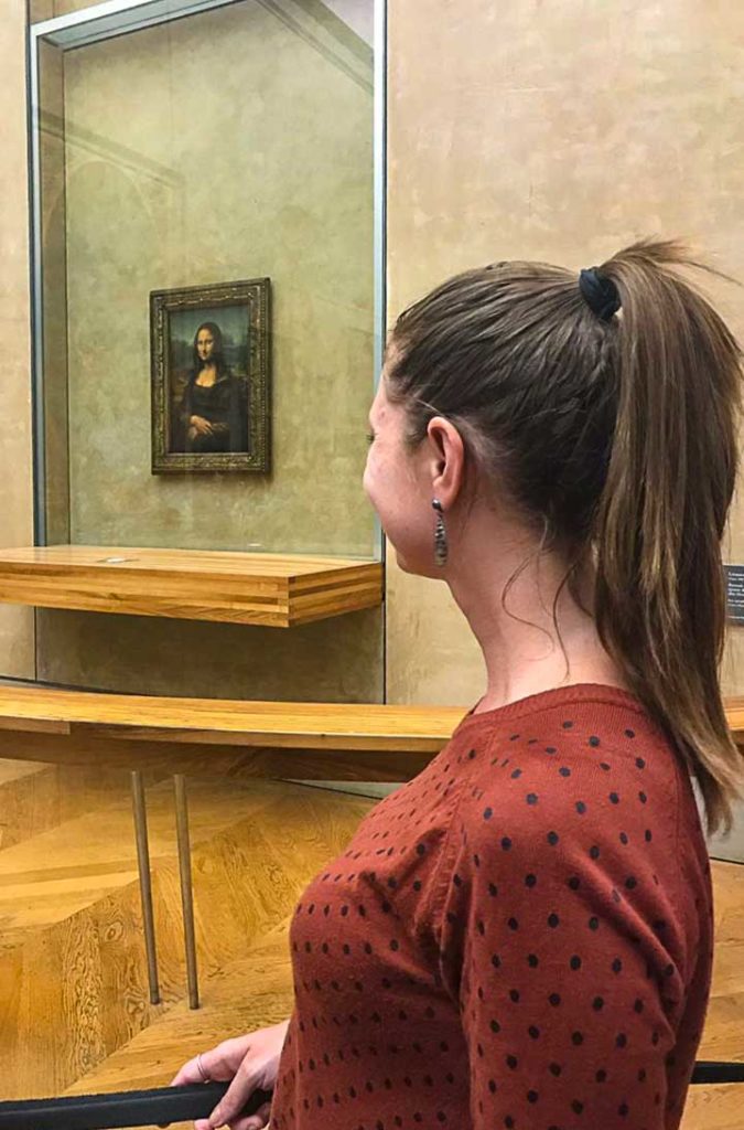 Mulher admira o quadro Mona Lisa, no Museu do Louvre, em Paris