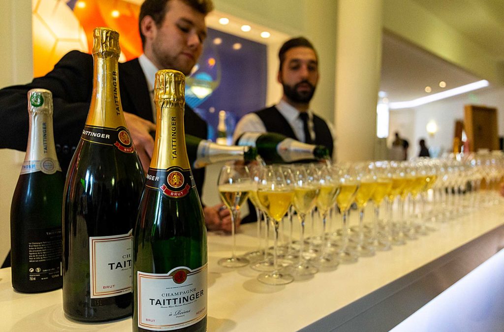 Garçom serve taças de champanhe na cava da Taittinger, em Reims