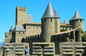Mulher posa para foto no alto das muralhas da cidade medieval de Carcassonne