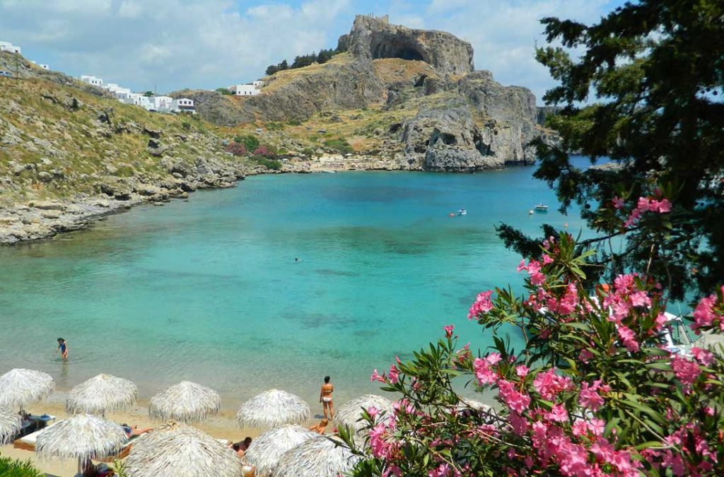 Praia de Saint Paul's Bay , na Grécia, com a Acrópole de Lindos ao fundo