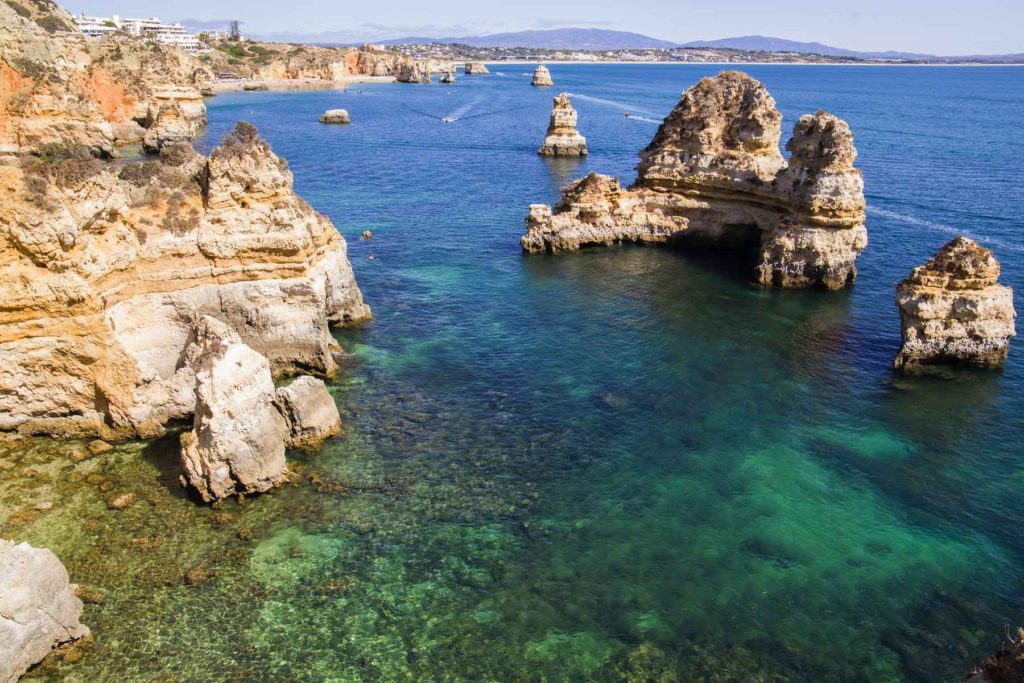 Dos alto dos paredões da Praia do Camilo, em Portugal, é possível ver belas formações rochosas no mar