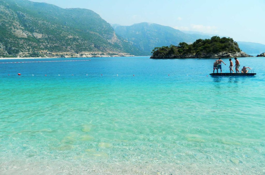 Jovens brincam sobre plataforma no mar na Blue Lagoon, praia de Oludeniz, na Turquia