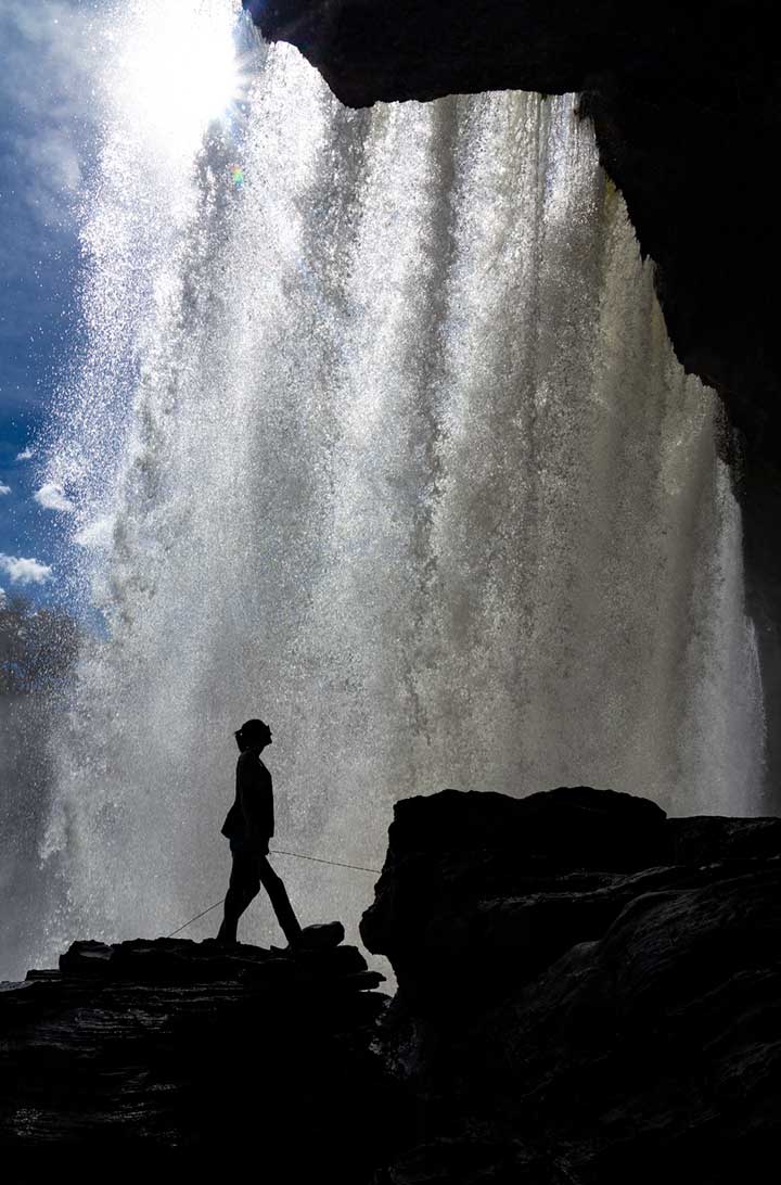 Mulher posa para foto atrás da Cachoeira de São Romão, na Chapada das Mesas (Brasil)