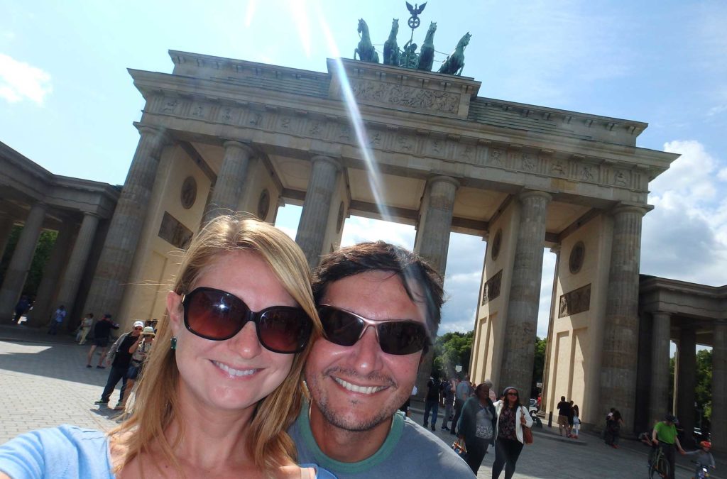 Casal posa para foto com o Portão de Brandemburgo ao fundo, em Berlim