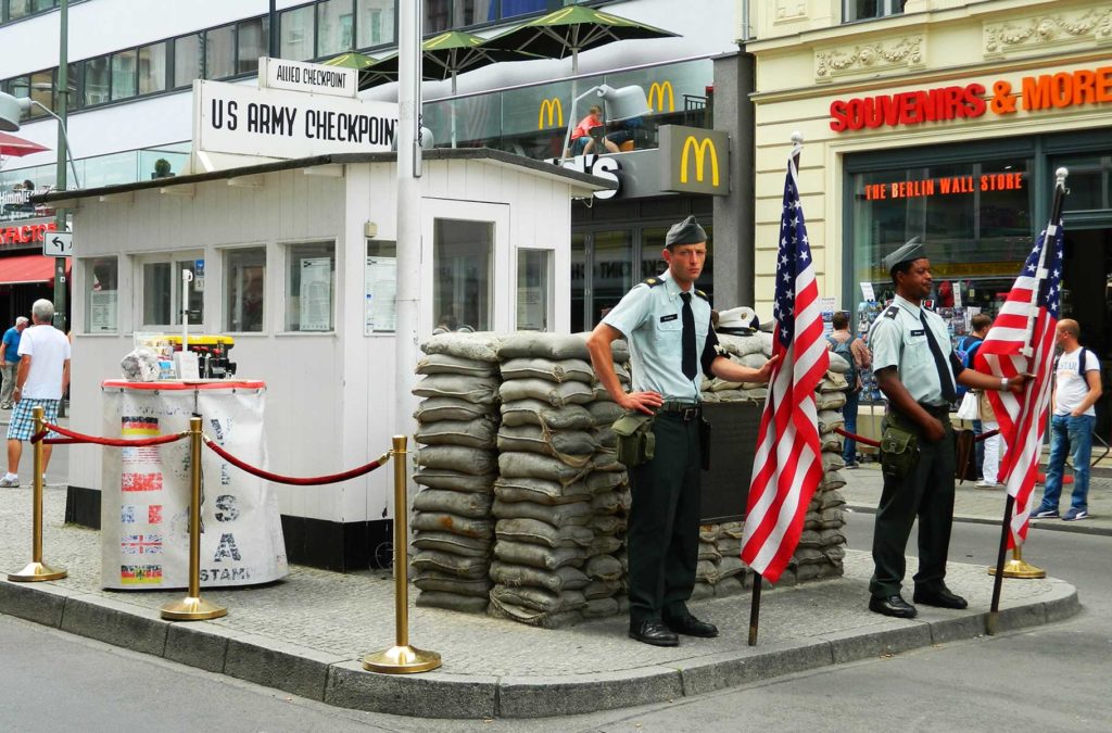 Atores vestidos de soldados posam para fotos no Checkpoint Charlie, em Berlim (Alemanha)