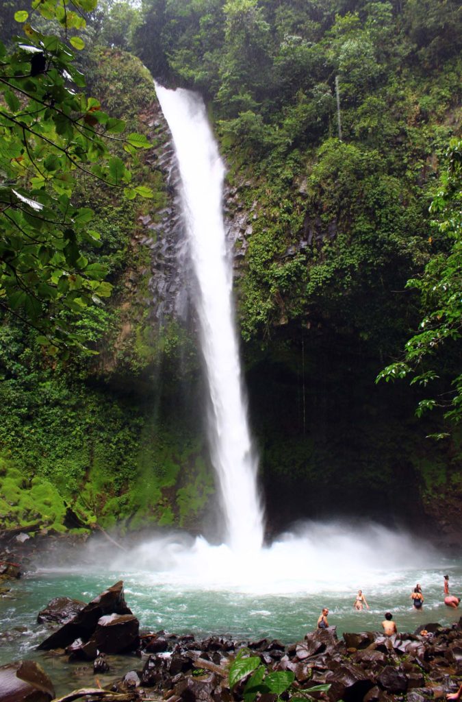 Turristas tomam banho na cachoeira La Fortuna