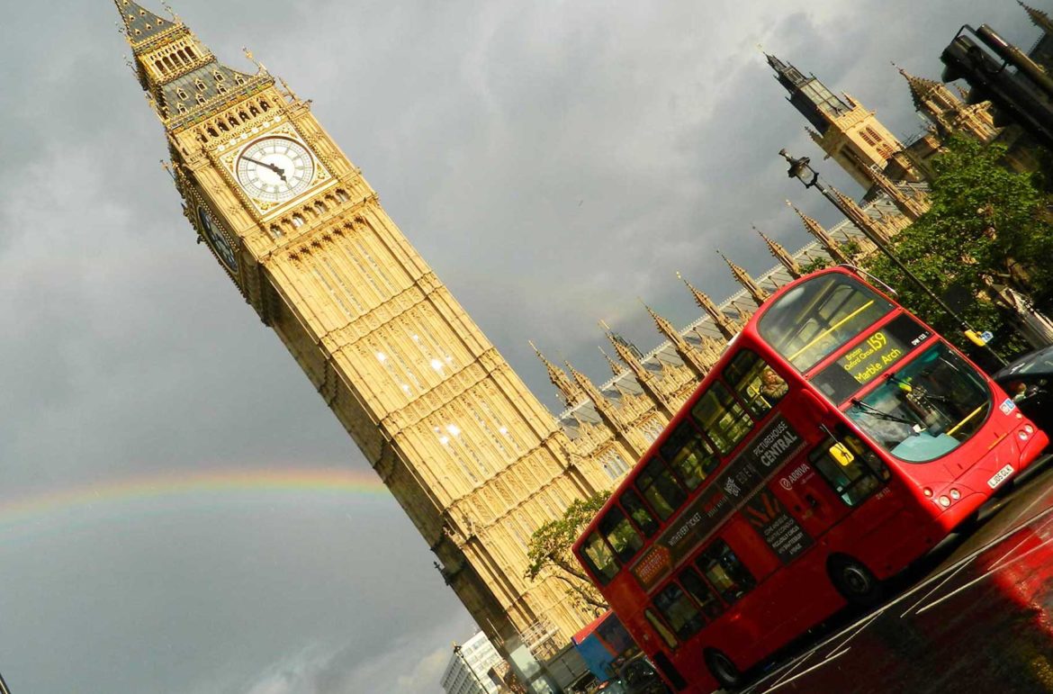 Ônibus vermelho de dois andares, típico de Londres, passa em frente ao Big Ben