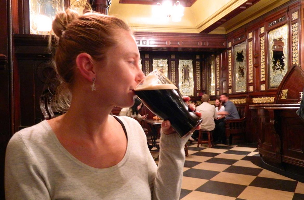 Mulher bebe pint de cerveja em um tradicional pub de Londres