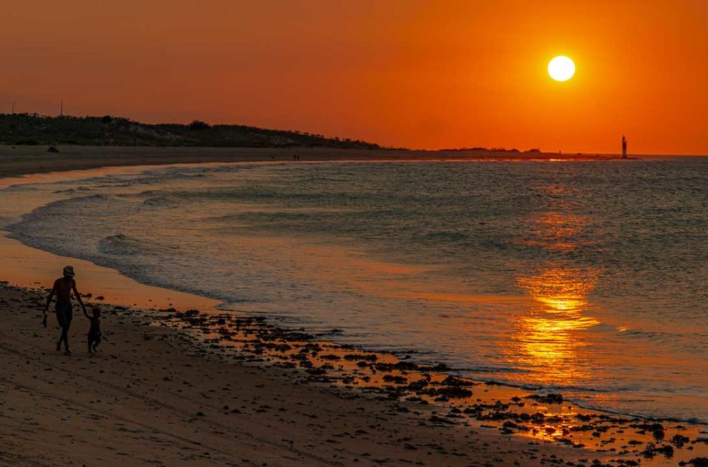 Pôr do sol ao lado do farol visto da praia principal de Galinhos