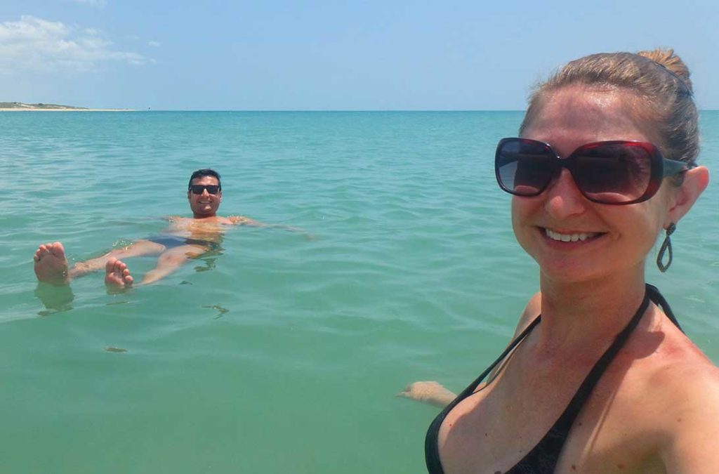 Turistas tomam banho no mar muito azul da Praia de Galinhos