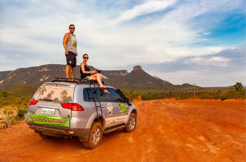 Casal de turistas posa para foto em cima de carro 4x4 no Parque Estadual do Jalapão