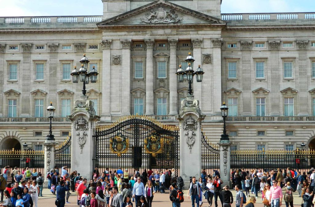 Turistas admiram a fachada do Palácio de Buckingham, em Londres