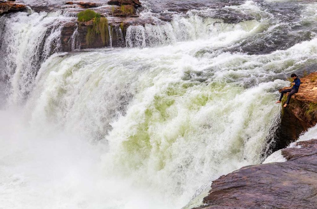 Turista senta nas pedras da Cachoeira da Velha