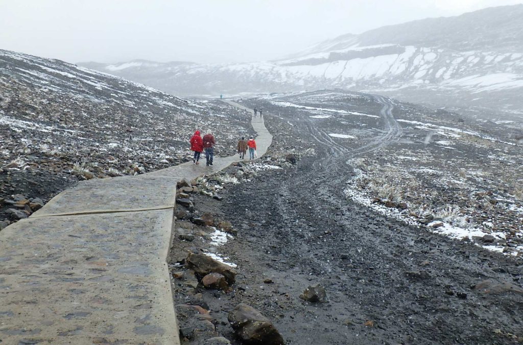 Turistas caminham em meio à neve até a Geleira Pastoruri, no norte do Peru