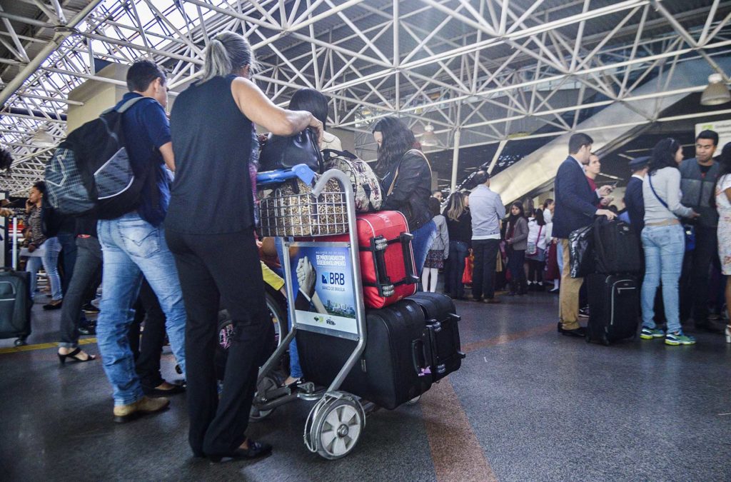 Passageiros esperam na fila para despachar malas em aeroporto