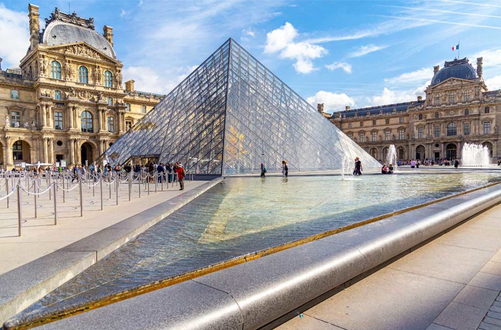 Visitantes fazem fila na entrada da pirâmide do Louvre