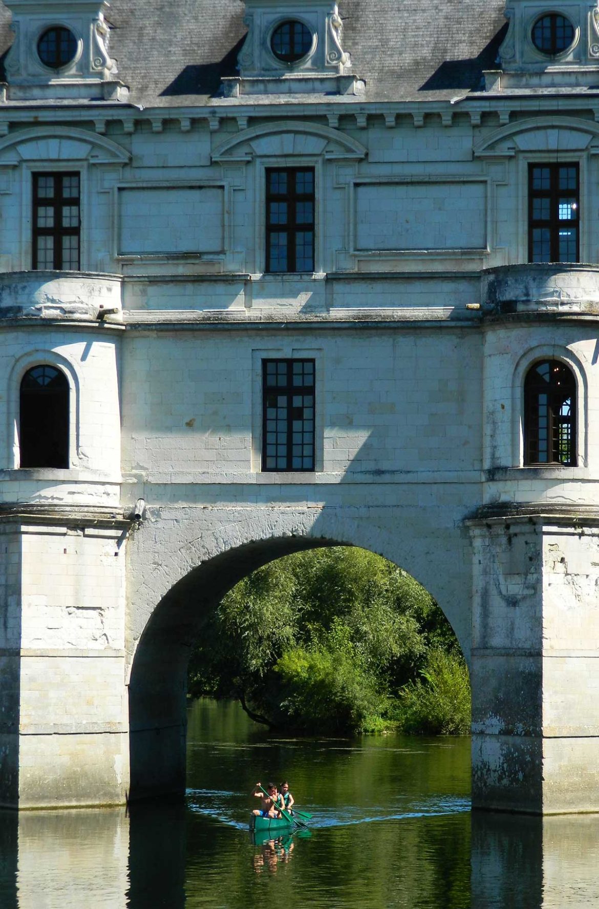 Barco navega no rio que passa sob o Castelo de Chenonceau