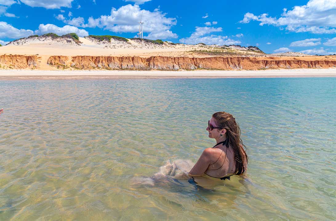 Mulher toma banho nas piscinas naturais da Praia de Canoa Quebrada