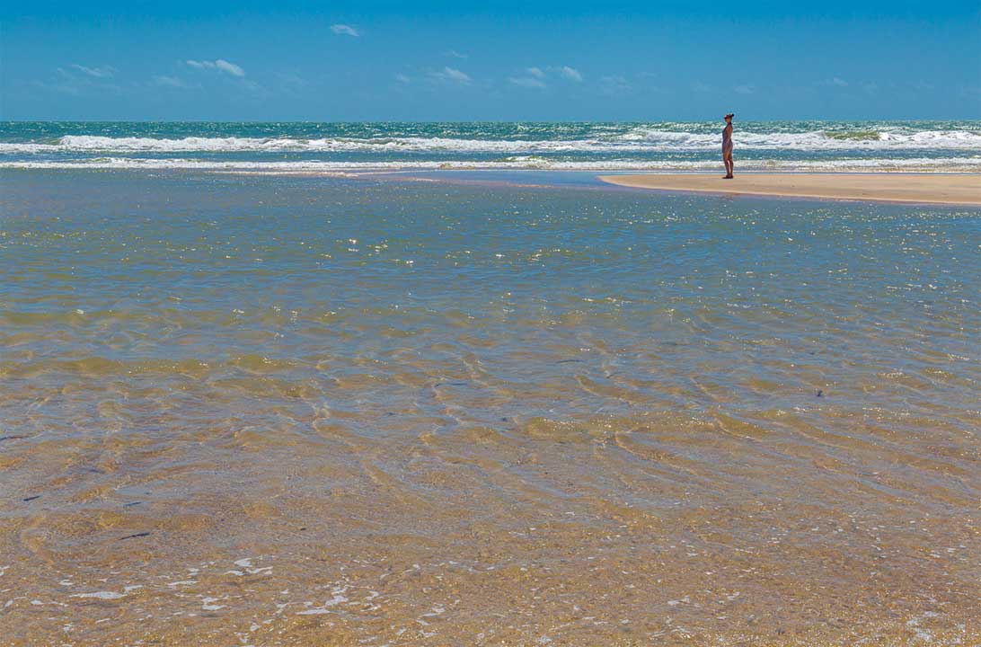 Mulher admira a Praia de Morro Branco, em Beberibe