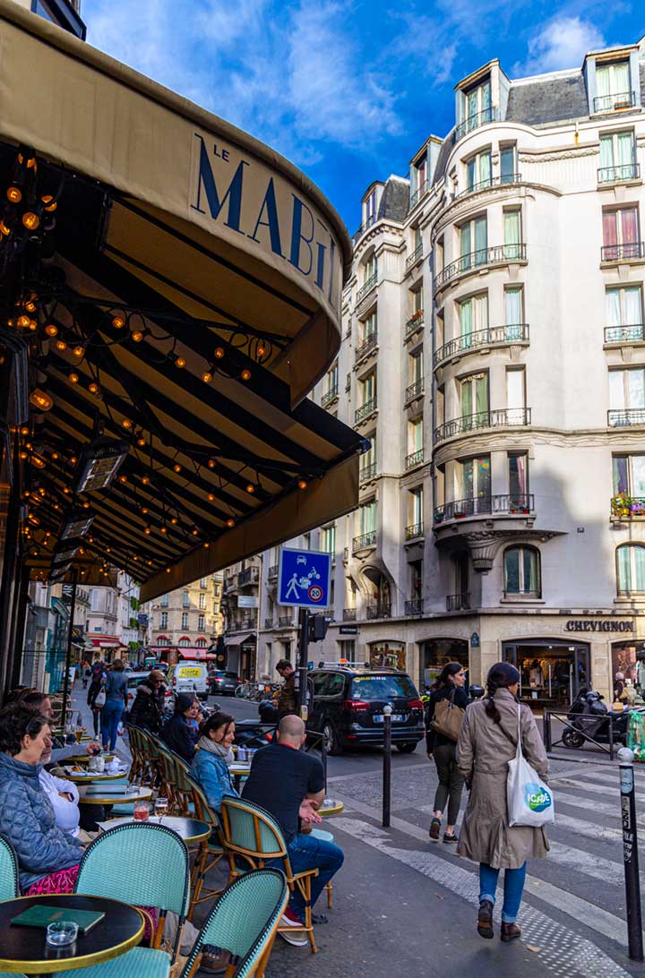Pessoas sentam na mesa de um café no bairro de Saint-Germain, em Paris