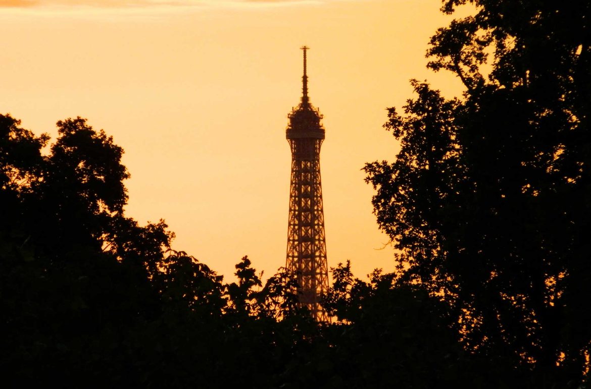 Silhueta da Torre Eiffel vista do Jardim das Tuileries, em Paris, ao entardecer