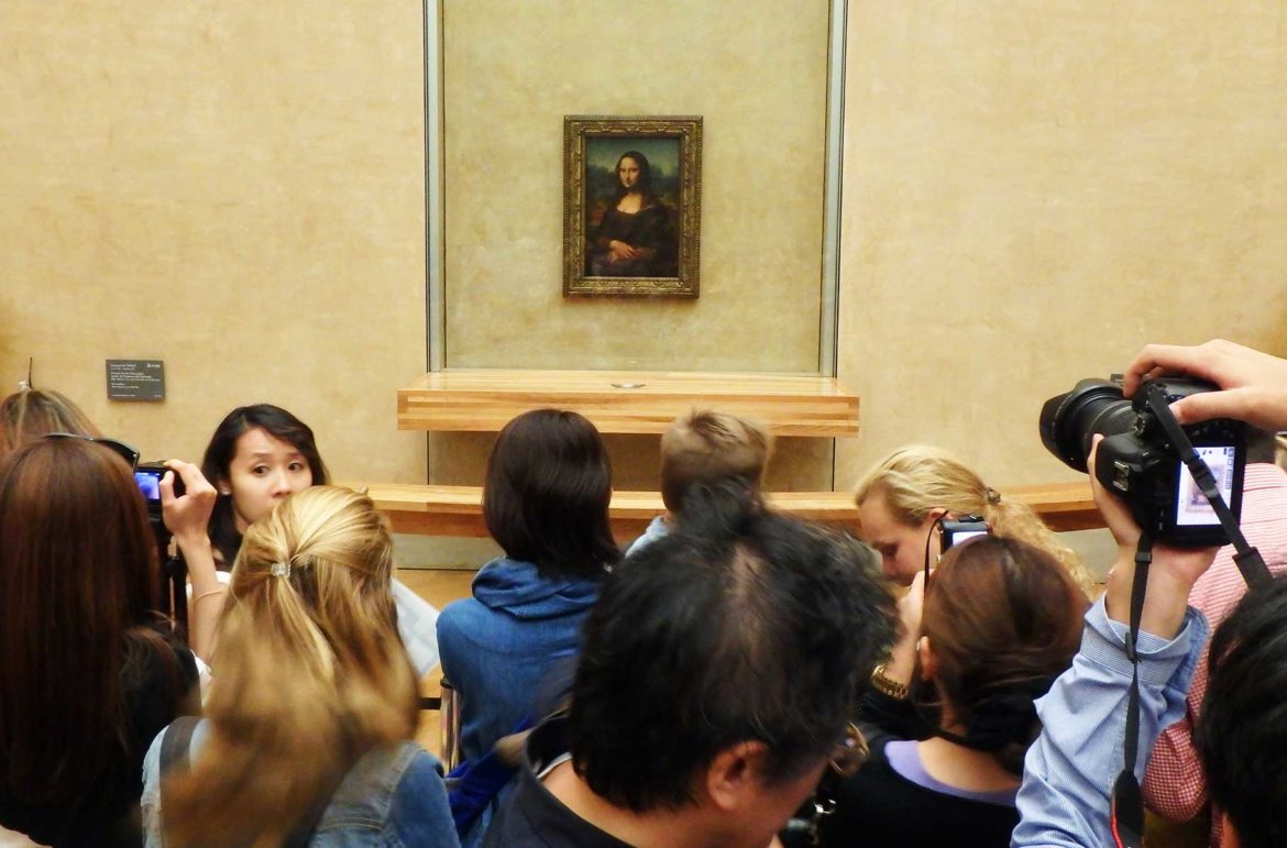 Público se aglomera em frente à Monalisa em exibição no Museu do Louvre, em Paris
