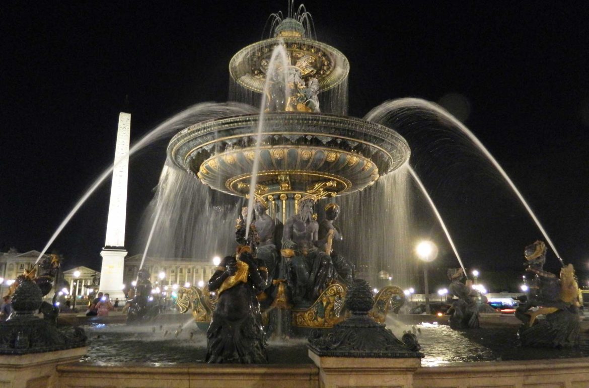 Fonte da Praça de la Concorde, com o Obelisco ao fundo, iluminada à noite, em Paris