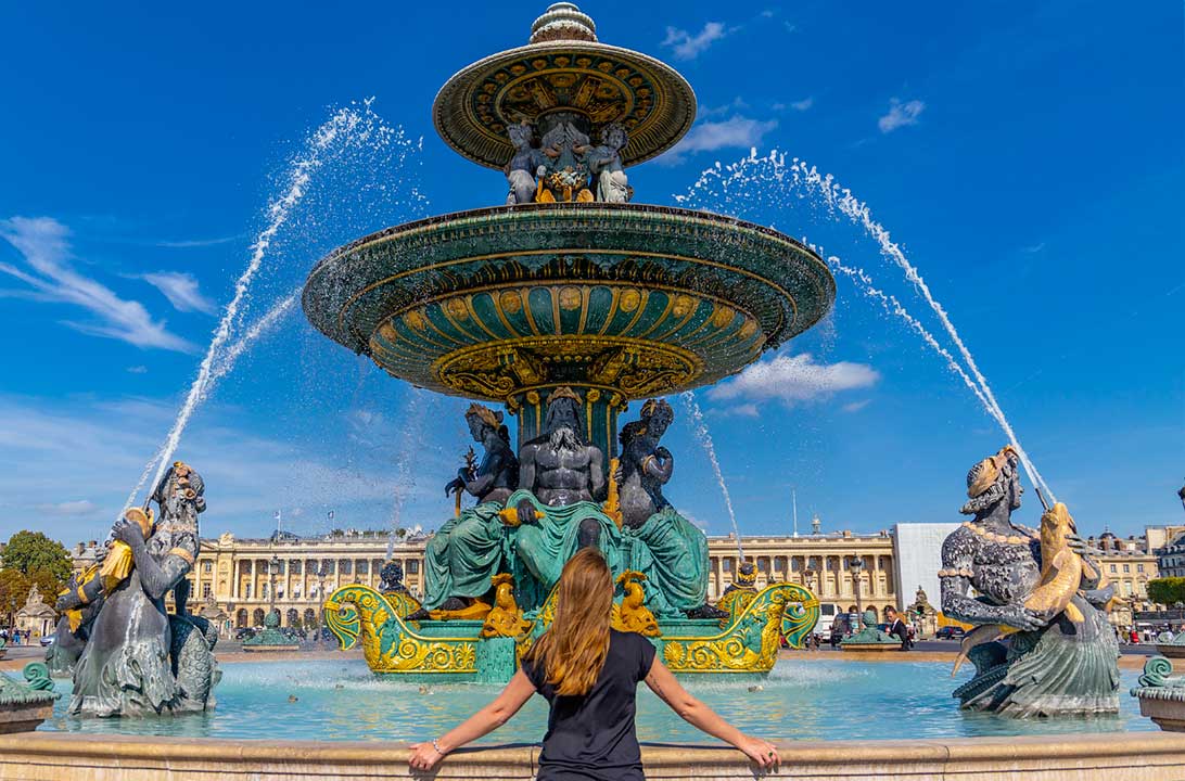 Mulher posa para foto na fonte da Praça de la Concorde, em Paris