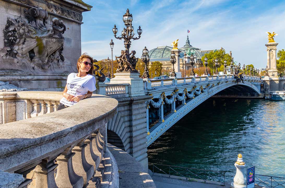 Mulher posa para foto na Ponte Alexandre III, em Paris