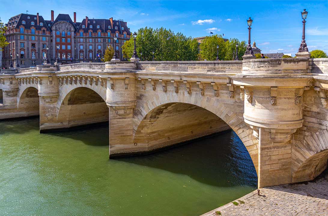Pessoas cruzam a Ponte Neuf sobre o Rio Sena, em Paris