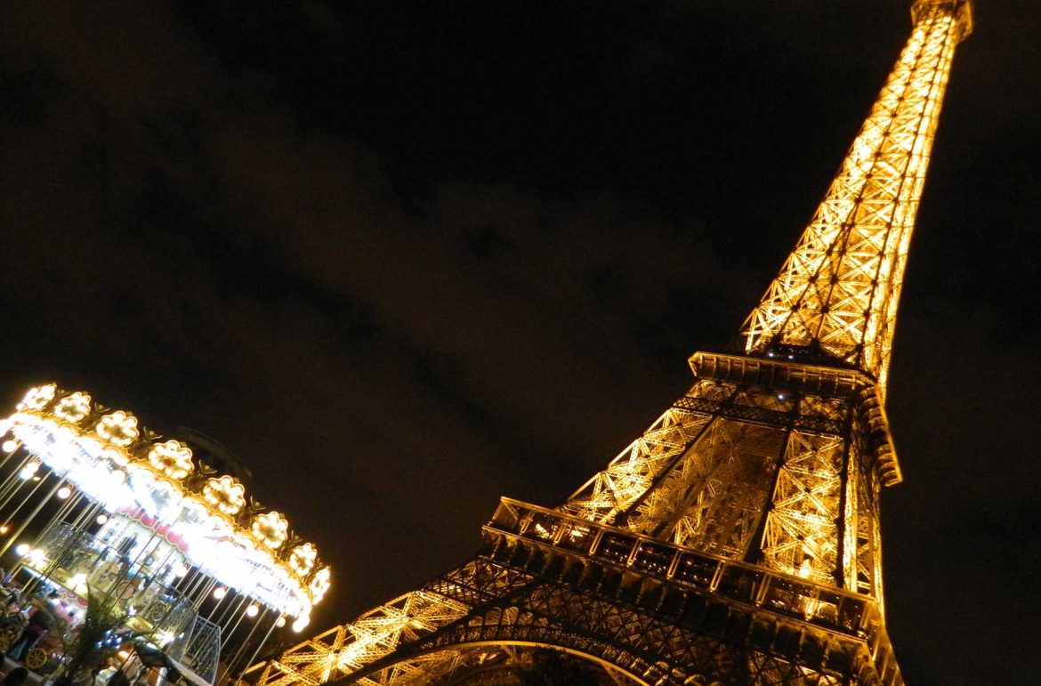 Carrossel da Ponte d'Iéna com a Torre Eiffel iluminada ao fundo, em Paris