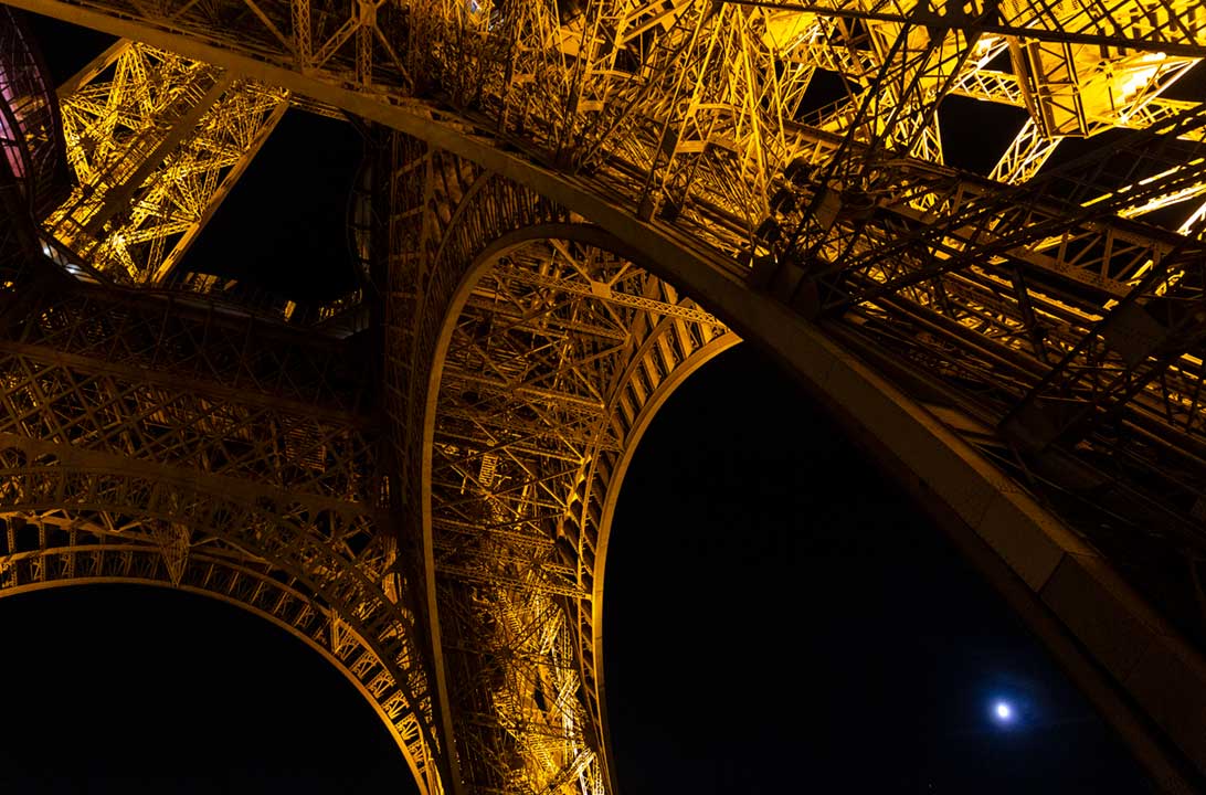 Torre Eiffel iluminada à noite, em Paris