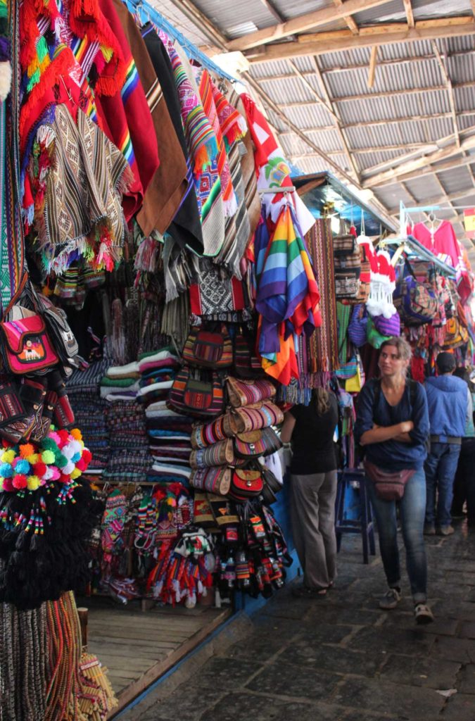 Turista admira produtos típicos de Cusco no Mercado San Pedro