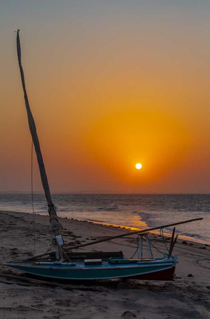 Jangada parada na areia durante o pôr do sol na Praia de Ponta Grossa, em Icapuí