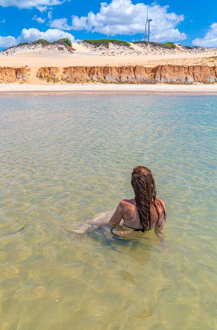 Mulher toma banho nas piscinas naturais da Praia de Canoa Quebrada