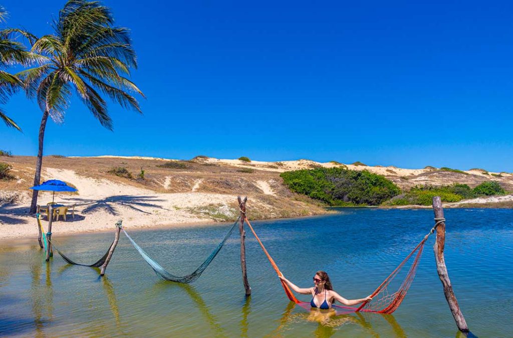 Mulher senta em rede dentro da lagoa Piscina dos Portugueses, na Praia das Fontes