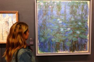 Visitante admira o quadro Lírios D’água Azuis, de Claude Monet