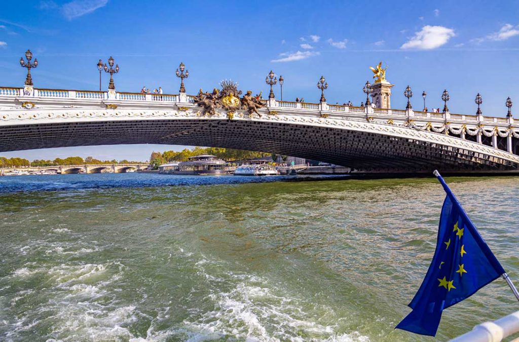 Barco no Rio Sena passa sob a Ponte Alexandre III, em Paris