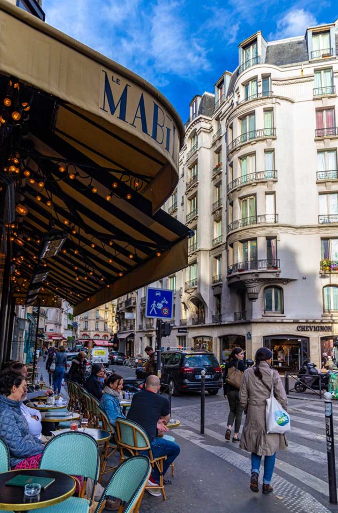 Pessoas sentam na mesa de um café no bairro de Saint-Germain, em Paris