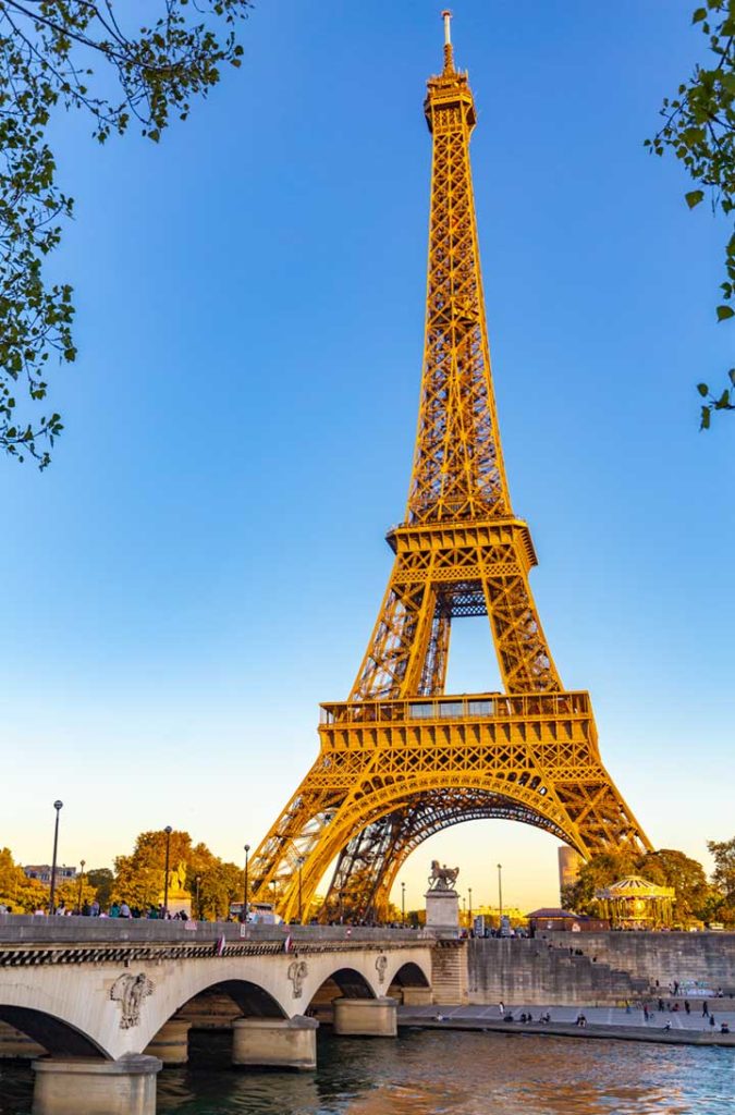 Torre Eiffel iluminada pelo pôr do sol do outro lado do Rio Sena, em Paris