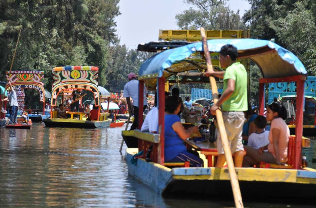 Barcas coloridas levam visitantes pelos canais de Xochimilco, na Cidade do México