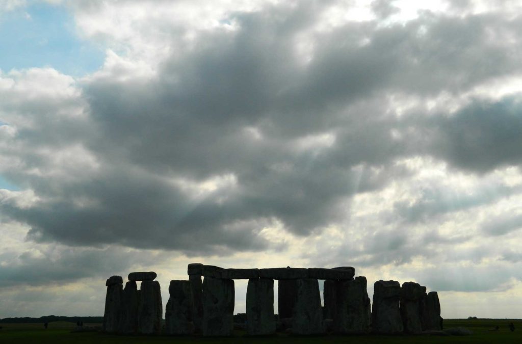 Silhueta do monumento de Stonehenge contrasta contra o céu do fim de tarde em Salisbury