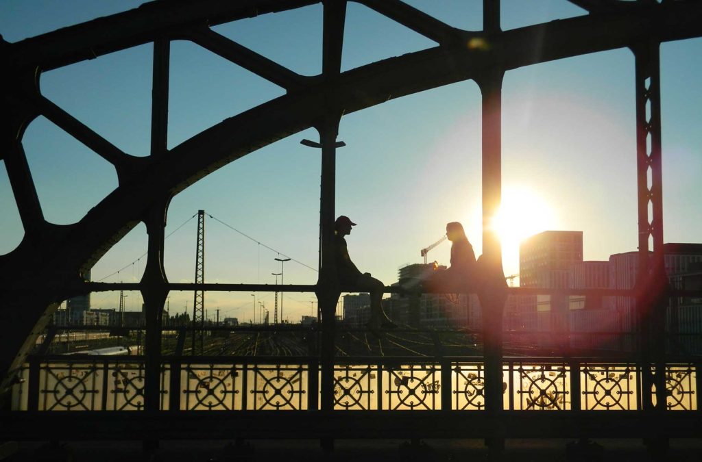 Casal admira o pôr do sol na Ponte Hackerbrücke, em Munique
