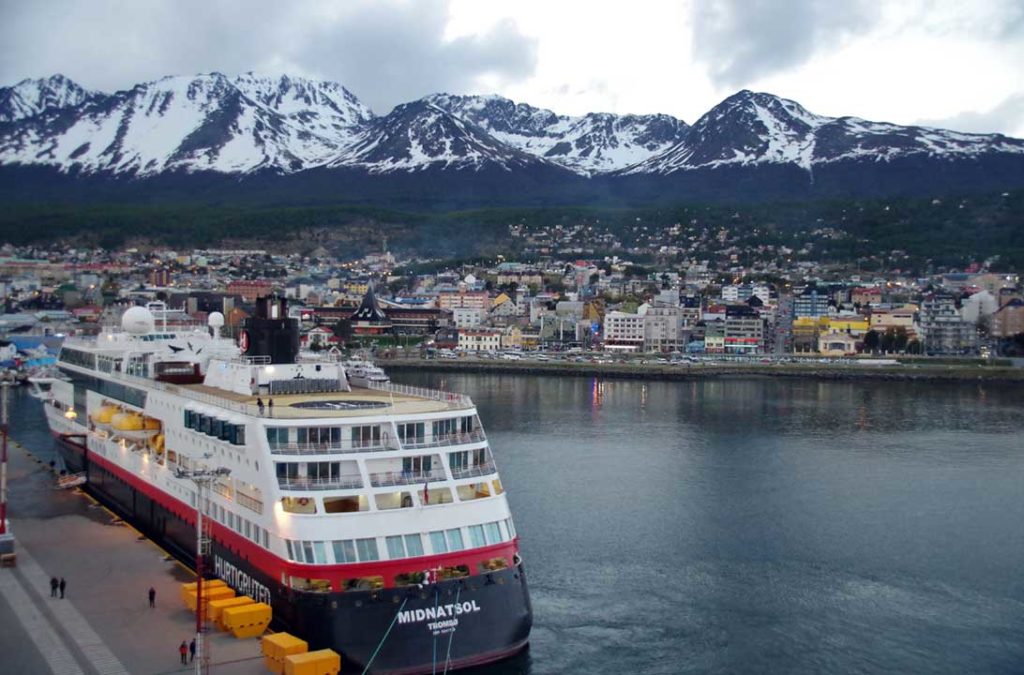 Navio de cruzeiro ancorado no porto com a cidade de Ushuaia ao fundo