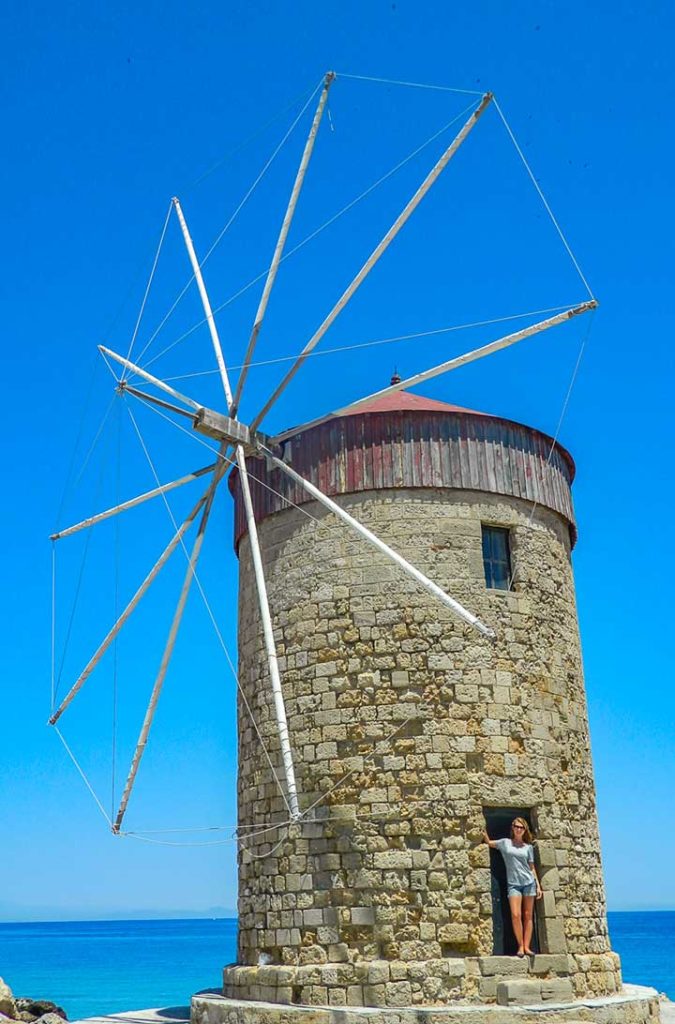 Mulher posa para foto em um dos moinhos de vento de Rhodes