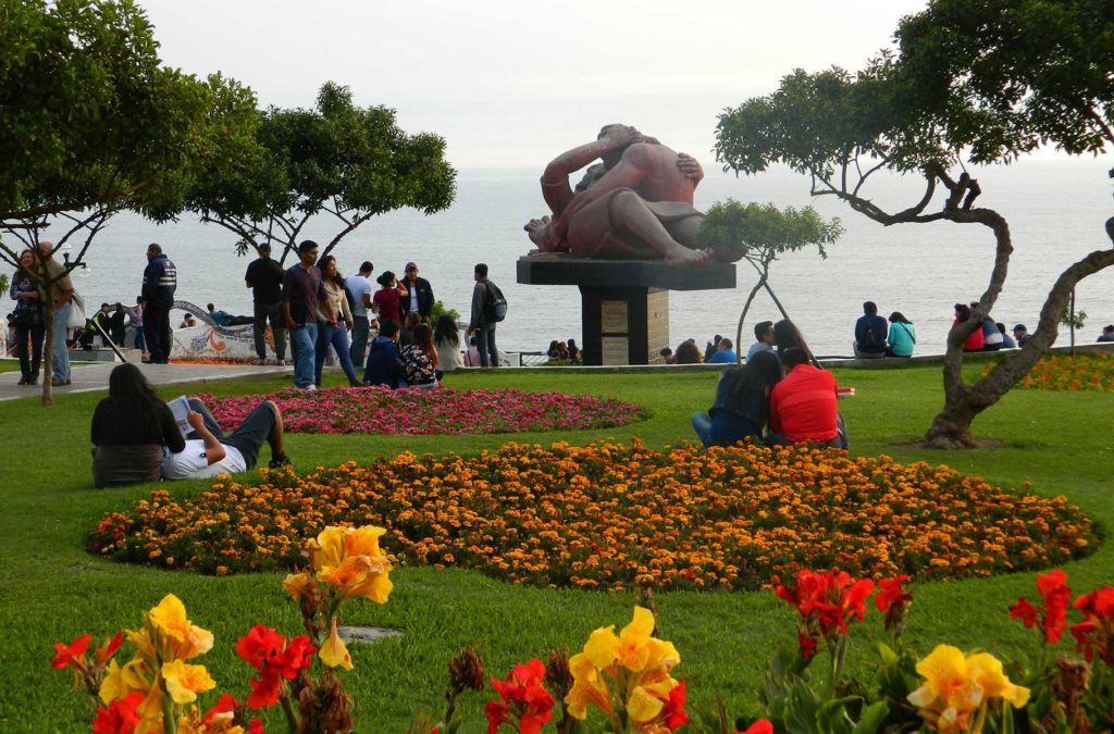 Canteiros floridos no Parque del Amor, com a estátua El Beso ao centro