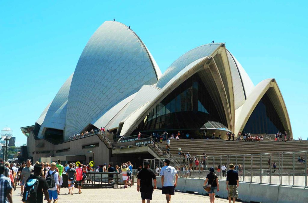 Visitantes caminham perto da Opera House, em Sydney